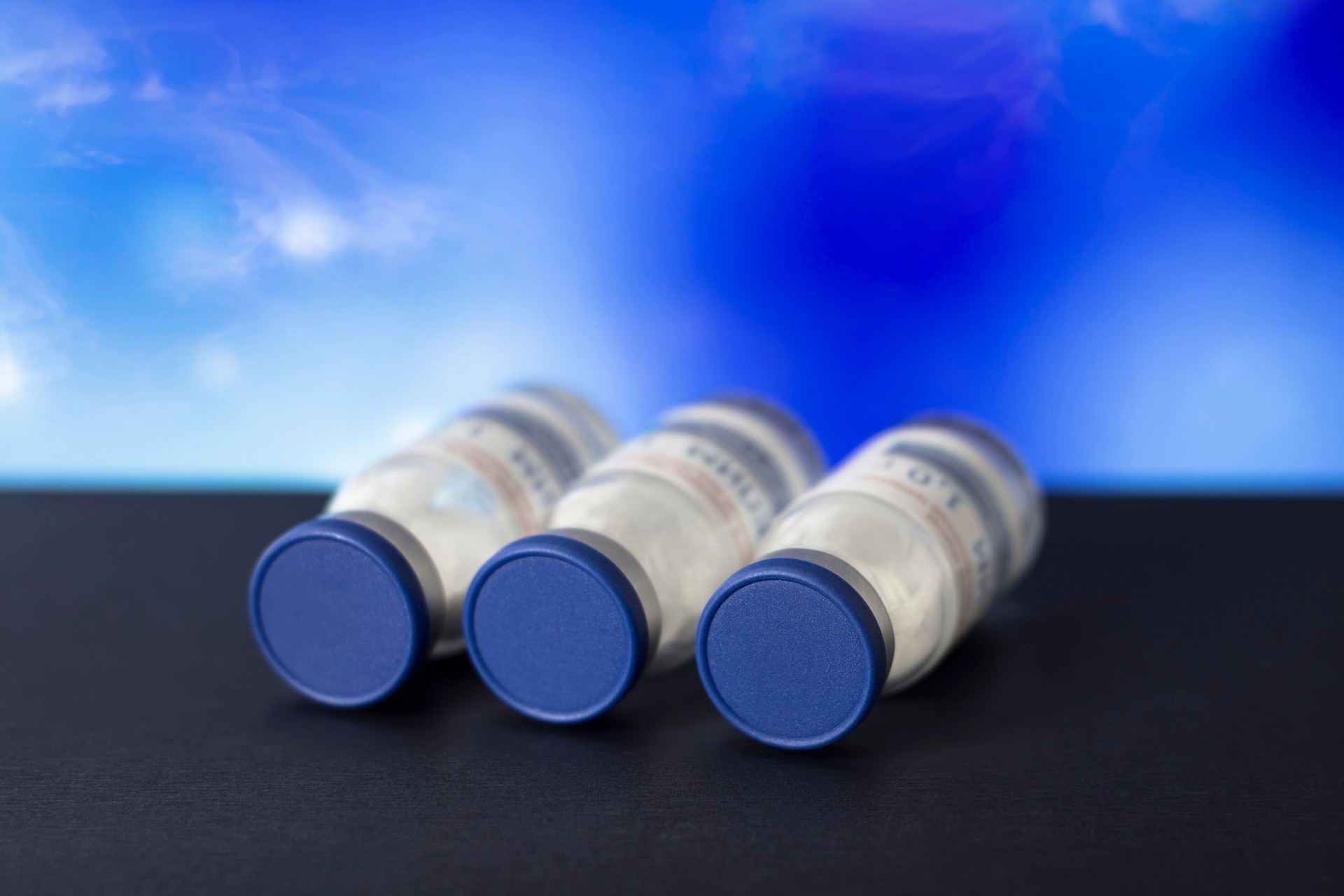 Vaccine bottles on a blue background. Medicine.